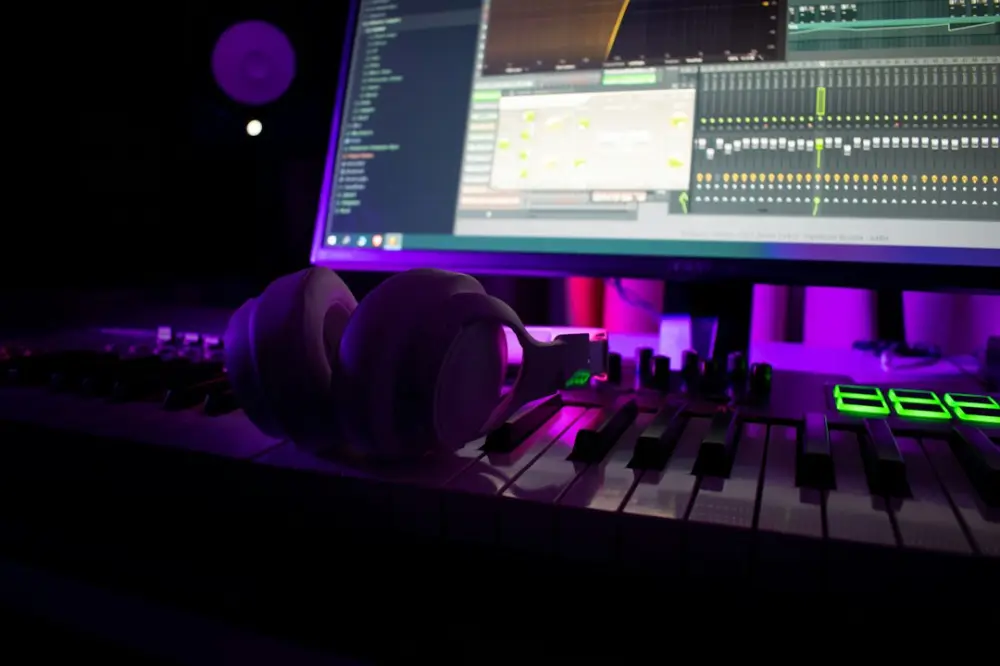Headphones rest on a music production keyboard, illustrating audiobook production