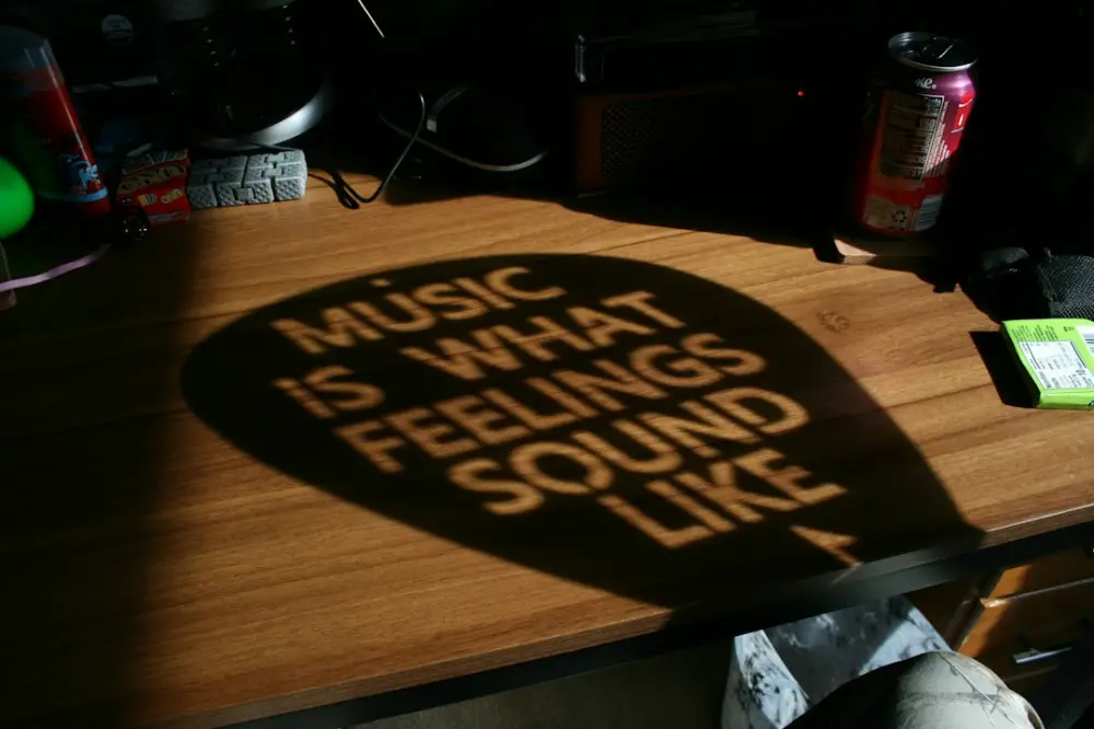 Shadowed quote 'music is what feelings sound like' on desk, illustrating sound design around spoken narratives